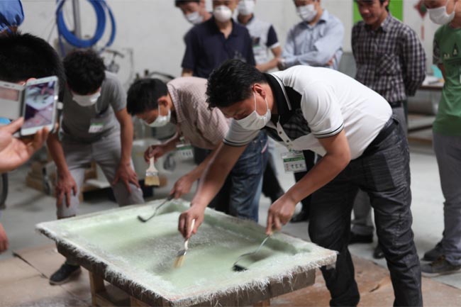 噴涂完成后，用輥筒壓實玻纖